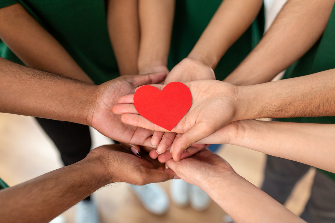 Close up of Volunteers's Hands Holding Red Heart